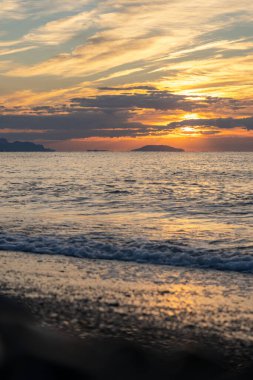Tropik sahilde inanılmaz bir gün doğumu. Denizin üzerinde sarı güneş. Turuncu renk dalgaları. Doğa geçmişi. Güzel sakin bir sahne. - Günaydın. Güneş ışığı su yüzeyine yansıyor