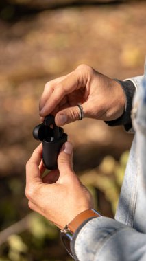 Siyah kablosuz kulaklık veya kulaklık, plastik kutu veya depolama ve şarj için kutu ve ahşap arka planda akıllı telefon, kapat