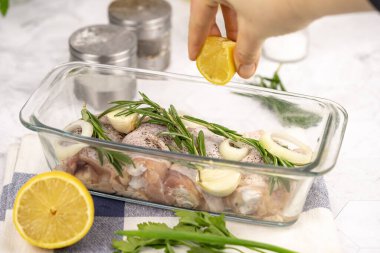 Masada çiğ tavuk budu. Mutfakta tavuk pişirmek. Beyaz arka planda çiğ tavuk budu..