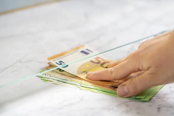 Person pay money to teller at cash department window, closeup. Exchange a 50 and 100 euro notes to buy and sell.