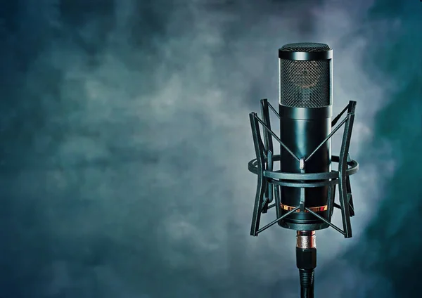 Stüdyo mikrofonu, grunge mavisi arka planda. Bir müzik şablonu üzerinde profesyonel ekipman, metin için kopyalama alanı