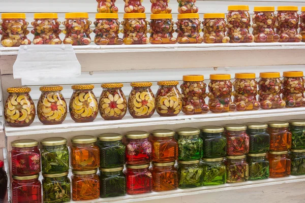 Pazar rafındaki bitki ve ladin dallarından bal ve reçele bulanmış fındıklar. Egzotik güney tatlıları. Seçici odak.