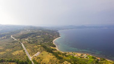 Yunanistan 'daki görkemli plajları ziyaret et. Halkidiki 'deki Sithonia yarımadasındaki cennet deniz manzarası. Otantik tatil köyünün çatısının üstünde.