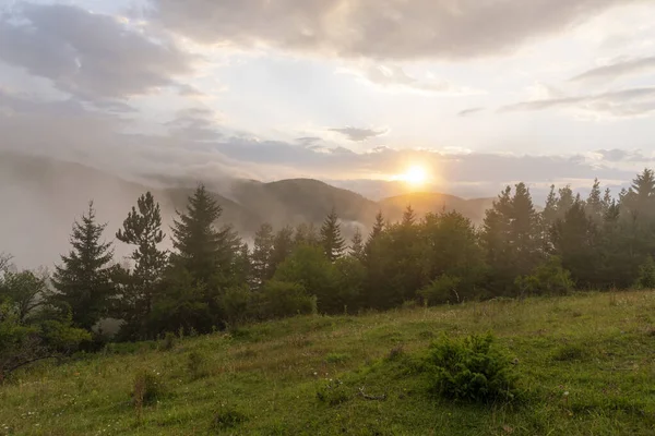 霧の中でカラフルな夕日と素晴らしい山の風景 — ストック写真