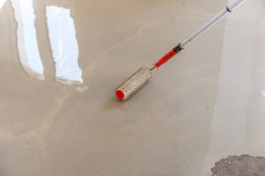 Zemini dümdüz etmek için iğne silindiri. Yerleri çimento karışımıyla döşemek..