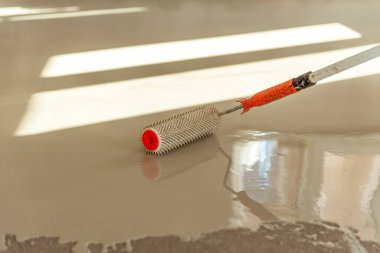 Zemini dümdüz etmek için iğne silindiri. Yerleri çimento karışımıyla döşemek..