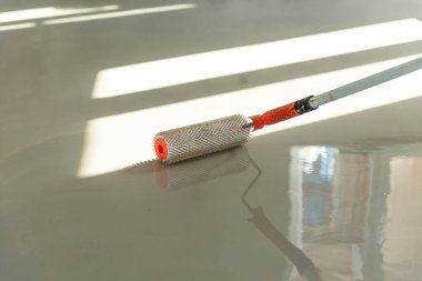 Zemini dümdüz etmek için iğne silindiri. Yerleri çimento karışımıyla döşemek..