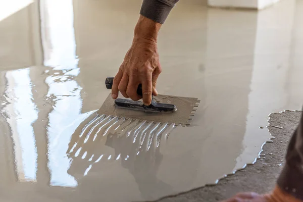 建筑工人正在用自平环氧树脂的方法对地板进行喷漆 自平平环氧树脂 与水泥地板的混合物平平 — 图库照片