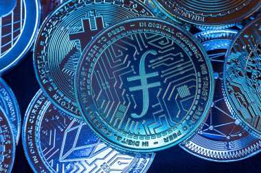 Yukarıdan siyah arkaplan üzerinde görülen Filecoin, Bitcoin, dogecoin ve ethererum gibi kripto para birimlerinin yatay görünümü