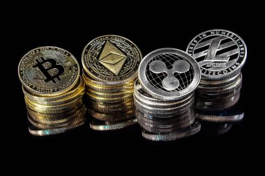Bitcoin, Ethererum Ripple ve Litecoin dahil olmak üzere kripto para birimi simgelerinin yatay görünümü yukarıdan siyah arkaplan üzerinde görüldü