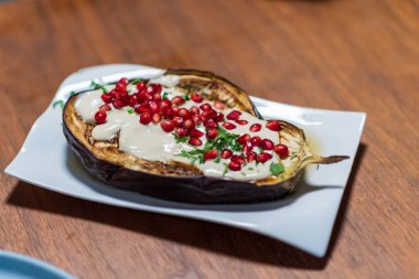 Tahini soslu ızgara patatesler ve nar tohumları.