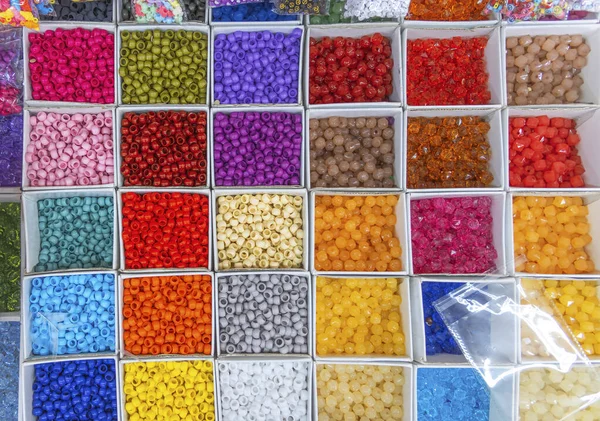 Pärlor arrangeras och sorteras efter färg. Bakgrund av färgglada ljusa pärlor i lådor, set för handarbete. — Stockfoto