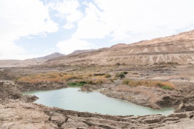 Ölü Deniz kıyısı yakınlarında, turkuaz suyla dolu bir subatan. Deniz seviyesindeki düşüşün devam etmesi nedeniyle tatlı su girmesiyle yeraltı tuzu çözüldüğünde delik oluştu.. 