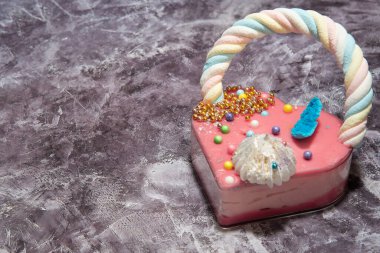  Gri mermer arka planda pembe kalp şeklinde kek ve bir sürü küçük renkli şeker. Sevgililer Günü. Aşk hakkında. Boşluğu kopyala