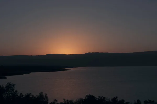 Orange sunrise reflecting off of the Dead Sea.