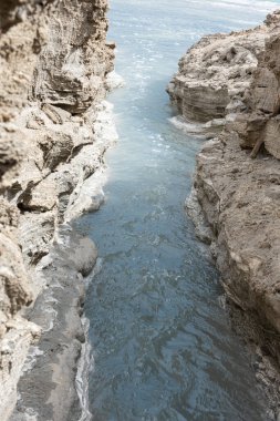 Ölü Deniz kıyısı yakınlarında, turkuaz suyla dolu bir subatan. Deniz seviyesindeki düşüşün devam etmesi nedeniyle tatlı su girmesiyle yeraltı tuzu çözüldüğünde delik oluştu. - Evet. Yüksek kalite fotoğraf