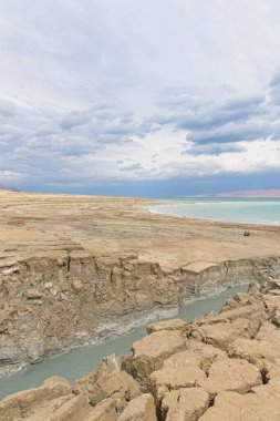 Ölü Deniz kıyısı yakınlarında, turkuaz suyla dolu bir subatan. Deniz seviyesindeki düşüşün devam etmesi nedeniyle tatlı su girmesiyle yeraltı tuzu çözüldüğünde delik oluştu. - Evet. Yüksek kalite fotoğraf