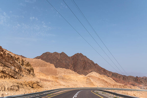 A road next to a mountainous desert landscape. Road 12 on the way to Eilat, Israel, on the Egyptian border. Mountains in different and varied sand colors. High quality photo