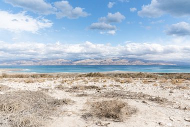 Fırtınalı bir kış gününde Ölü Deniz 'in subatan bölgesinin egzotik manzarası. Ölü Deniz kıyılarında fotoğraf fırtınası ve yağmur. Gün batımında tuz kristalleri. Ölü denizin dokusunu. Tuzlu deniz kıyısı. Yüksek