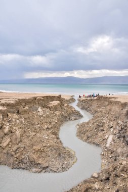 Ölü Deniz kıyısı yakınlarında, turkuaz suyla dolu bir subatan. Deniz seviyesindeki düşüşün devam etmesi nedeniyle tatlı su girmesiyle yeraltı tuzu çözüldüğünde delik oluştu. - Evet. Yüksek kalite fotoğraf