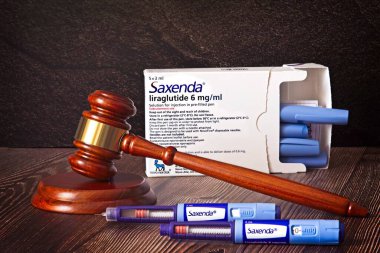 Hakimler çekiç, Saxenda enjeksiyon kalemleri ahşap arka planda. Kilo vermek için iğne, kan şekerini düşürmek ve açlığı bastırmak için. Tıbbi muhakeme konsepti. Yüksek kalite fotoğraf