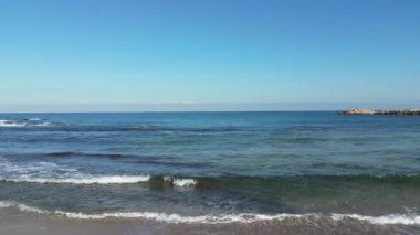Sea waves gently crash on the beach coast. Givat Alia, Jaffa, Israel. High quality 4k footage