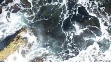 Aerial straight down view of the gorgeous and rugged Old Jaffa coastline. The camera moves steadily along the rocky bluffs ending in a magnificent swirl of ocean and rocks. 4k footage