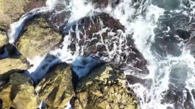 Aerial straight down view of the gorgeous and rugged Old Jaffa coastline. The camera moves steadily along the rocky bluffs ending in a magnificent swirl of ocean and rocks. 4k footage