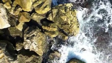 Aerial straight down view of the gorgeous and rugged Old Jaffa coastline. The camera moves steadily along the rocky bluffs ending in a magnificent swirl of ocean and rocks. 4k footage