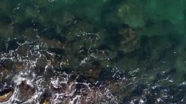 Aerial straight down view of the gorgeous and rugged Old Jaffa coastline. The camera moves steadily along the rocky bluffs ending in a magnificent swirl of ocean and rocks. 4k footage