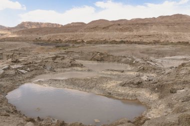 Ölü Deniz kıyısı yakınlarında, turkuaz suyla dolu bir subatan. Deniz seviyesindeki düşüşün devam etmesi nedeniyle tatlı su girmesiyle yeraltı tuzu çözüldüğünde delik oluştu. - Evet. Yüksek kalite fotoğraf