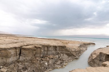 Ölü Deniz kıyısı yakınlarında, turkuaz suyla dolu bir subatan. Deniz seviyesindeki düşüşün devam etmesi nedeniyle tatlı su girmesiyle yeraltı tuzu çözüldüğünde delik oluştu. - Evet. Yüksek kalite fotoğraf