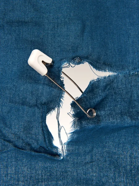 Safety pin holding torn fabric — Stock Photo, Image