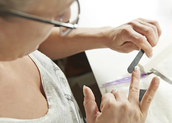 Woman filing her nails Stock Photo