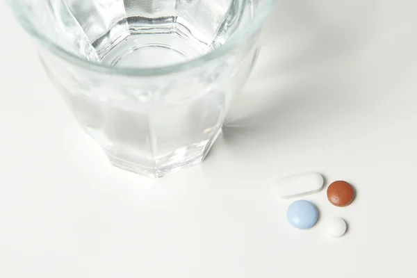 Pillole e una ciotola d'acqua — Foto Stock