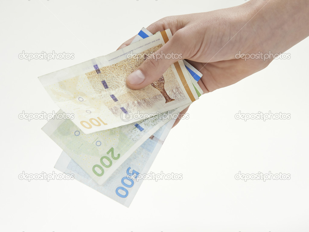 A hand holding Danish currency
