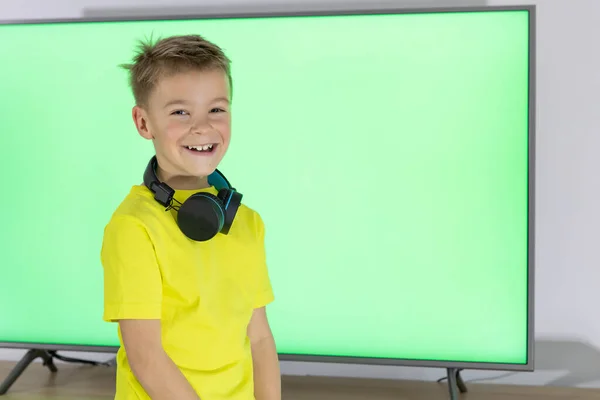 小男孩在跳舞 带着耳机在电视前跳舞唱歌的孩子 — 图库照片