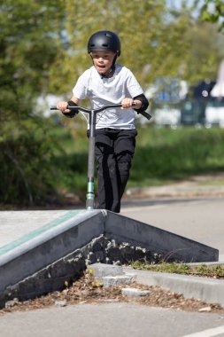 Çocuk bir scooter 'a atlıyor.