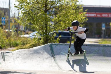 Çocuk bir scooter 'a atlıyor.