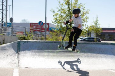 Çocuk bir scooter 'a atlıyor.