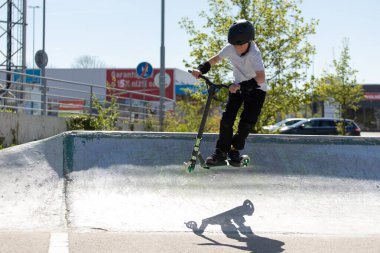 Çocuk bir scooter 'a atlıyor.