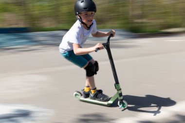 Çocuk bir scooter 'a atlıyor.