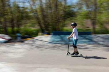 Çocuk bir scooter 'a atlıyor.
