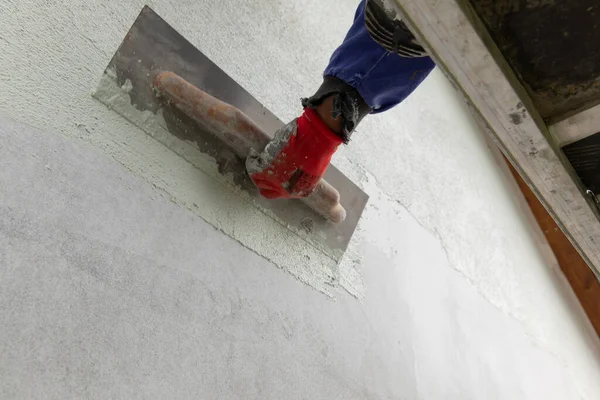 Close-up of a worker\'s hand doing the finishing touches.