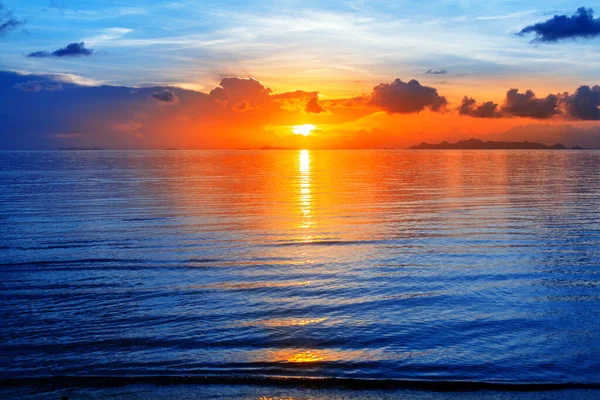 色彩艳丽的海景 明亮的海洋日出 金黄的阳光反射 蓝色的水波 橘红色的天空 美丽的热带岛屿海滨风景 免版税图库照片