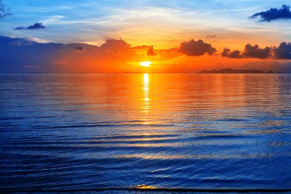 色彩艳丽的海景 明亮的海洋日出 金黄的阳光反射 蓝色的水波 橘红色的天空 美丽的热带岛屿海滨风景 图库图片
