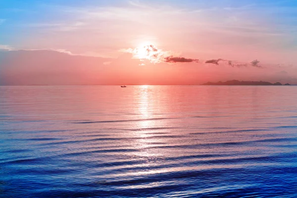 美丽的海日落 热带岛屿海滩 柔和的粉色天空云彩 阳光反射 蓝色水波 船型轮廓 黎明景观 图库照片