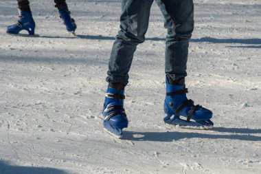 Bibbiano, Aralık 2021. Kasaba meydanında küçük bir buz pateni pistinde bacaklar ve patenler.