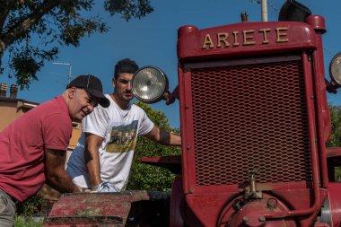 İtalyan çocuklar Bubba Ariete 'nin motorunu çalıştırıyor, kızgın başlı traktör.