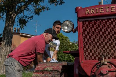 İtalyan çocuklar Bubba Ariete 'nin motorunu çalıştırıyor, kızgın başlı traktör.